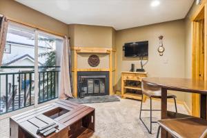 a living room with a fireplace and a table at Tannhauser II 15 in Breckenridge