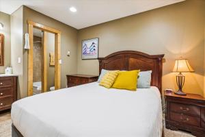 ein Schlafzimmer mit einem großen Bett mit gelben Kissen in der Unterkunft Tannhauser II 15 in Breckenridge