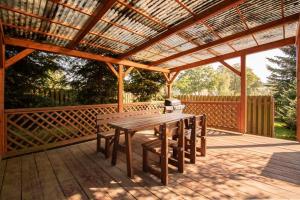 a wooden deck with a wooden table and benches at Penzion Avionika in Kovářská