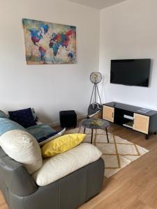 sala de estar con sofá y TV en Gîte mont-blan, en Pontorson