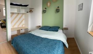 Un pequeño dormitorio con una cama y una escalera en Gîte mont-blan, en Pontorson