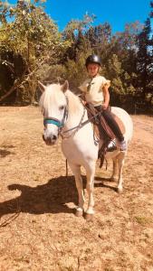 a young woman riding on a white horse at Chambres d'hôtes dans propriété rurale in Béziers