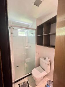 uma casa de banho com um WC e uma cabina de duche em vidro. em Prédio Solar do Atlântico - Apartamento lateral em Tambaú em João Pessoa