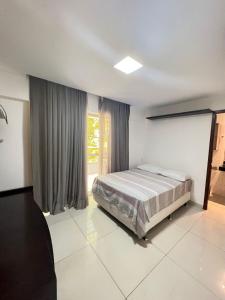 um quarto com uma cama e uma grande janela em Prédio Solar do Atlântico - Apartamento lateral em Tambaú em João Pessoa