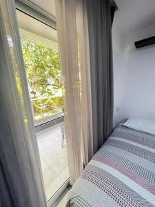 een slaapkamer met een bed en een groot raam bij Prédio Solar do Atlântico - Apartamento lateral em Tambaú in João Pessoa