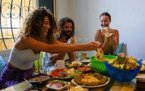 達哈布的住宿－Rafiki Hostels - Dahab，一群人坐在桌子旁吃着食物