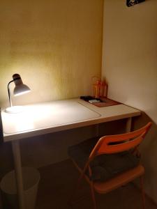 escritorio con lámpara y silla naranja en Двухкомнатные просторные апартаменты., en Imatra