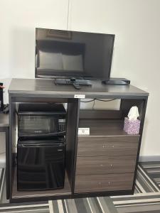 a desk with a television on top of it at Relax Inn - Saginaw in Saginaw