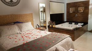 a bedroom with a bed and a bath tub at Chalé Canto do Galo 1 in Gonçalves