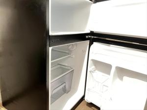 an empty refrigerator with its door open in a kitchen at Appartement Cosy au Centre des Mamelles By Hestia Lights in Dakar
