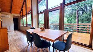 a table and chairs in a room with a large window at Redwood Retreat, Mountains, Adventure and Nature in Ponderosa