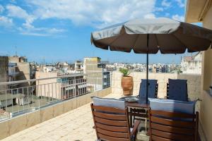 un tavolo e sedie con ombrellone su un balcone di Horizon /Downtown Penthouse w/ massive terrace a Salonicco