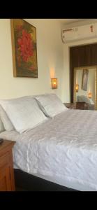 a bedroom with a white bed and a mirror at Pousada Belvedere da Serra in Serra do Cipo