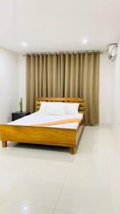 a bedroom with a wooden bed in front of a curtain at Lovely 4-bedroom Holiday home with free parking. in Lautoka
