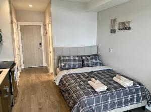 a bedroom with a bed with two towels on it at Lovely condo located close to downtown/waterfront! in Kelowna