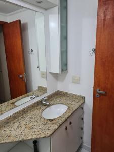 een badkamer met een wastafel en een spiegel bij AP1310 - Região dos hospitais, piscina e garagem in Sao Paulo