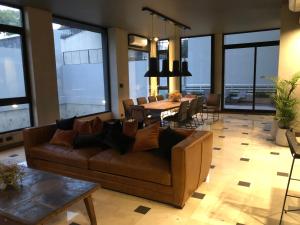 sala de estar con sofá y comedor en TOP RENTALS TOWER LE BLEU RIVERA en Buenos Aires