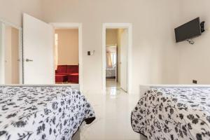 um quarto com duas camas e uma televisão na parede em The Green Palms 5 Bedroom villa with pool / garden em San Felipe de Puerto Plata