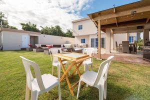 a wooden table and chairs in a yard at The Green Palms 5 Bedroom villa with pool / garden in San Felipe de Puerto Plata