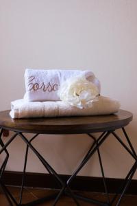 a towel with a flower on top of a table at Le Case di Sonia DEL CORSO CIV 25 Fucecchio in Fucecchio