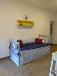 Cama en habitación con estante amarillo en la pared en Alma viajera en Posadas