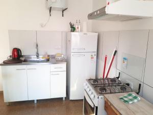 La cocina está equipada con electrodomésticos blancos y fogones. en Alma viajera en Posadas