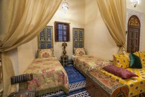 een slaapkamer met twee bedden en een raam bij Charmant appartement avec terrasse privee a fes medina in Fès +38 foto's