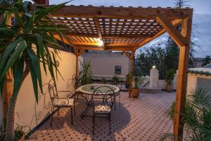 een patio met een tafel en stoelen onder een houten pergola bij Charmant appartement avec terrasse privee a fes medina in Fès