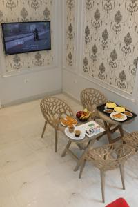 - un salon avec une table, des chaises et une télévision dans l'établissement New Midtown, au Caire