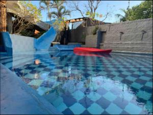 una piscina con una barca rossa nell'acqua di Casa Real Cozumel a Cozumel