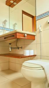 La salle de bains est pourvue de toilettes et d'un miroir. dans l'établissement Canto dos Pássaros Suítes, à Ubatuba