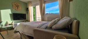 a bedroom with a bed and a large window at Le p'tit Saint-Pierre - Centre ville - Parking in Pontarlier