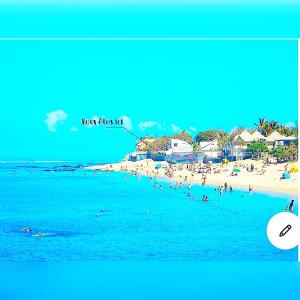a view of a beach with people in the water at Villa Maimouna les pieds dans l'eau in Saint-Pierre