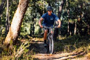 a man riding a bike on a trail in the woods at Patagonia East River in Llanada Grande