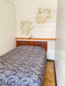 um quarto com uma cama e duas tartarugas na parede em Habitaciones Mar Azul em El Quisco