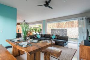 een woonkamer met een tafel en een bank bij Villa Lacasa2- modern tropical 2BR Villa with butler in Legian