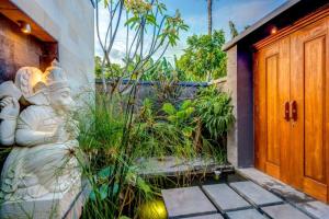a front door of a house with a statue next to it at Villa Lacasa2- modern tropical 2BR Villa with butler in Legian