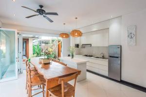 a kitchen with a wooden table and chairs at Villa Lacasa3 -Modern tropical 3BR Villa with butler in Legian