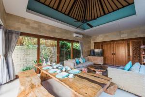 sala de estar con mesa y sofá en Villa Lacasa3 -Modern tropical 3BR Villa with butler en Legian
