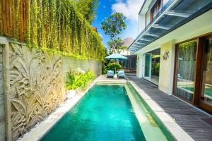 a swimming pool in the backyard of a home with a house at Villa Lacasa3 -Modern tropical 3BR Villa with butler in Legian