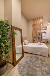 een slaapkamer met een bed met een spiegel en een plant bij Art Lofts Gardens in Valencia