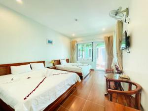 ein Hotelzimmer mit zwei Betten und einem Fernseher in der Unterkunft Phu Long Resort & Bar Phu Quoc in Phu Quoc