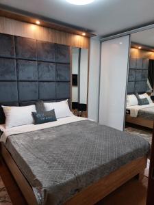 Un dormitorio con una cama grande y un espejo grande. en Merlin 22 DeLux, en Zlatibor