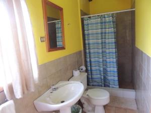 a bathroom with a white toilet and a sink at Hotel El Albergue Español in Puerto Misahuallí