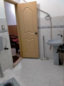 a bathroom with a yellow door and a sink at Five Giants Lahore Homestay in Lahore