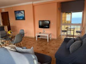 a living room with a couch and a tv at Las Delicias de Estepona in Estepona