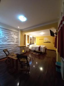 Hotel REY DAVID في أويوني: غرفة فندقية بسرير وطاولة وكراسي
