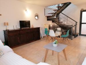 a living room with a staircase and a table and chairs at Apartment by the sea with WIFI & Netflix in El Cotillo