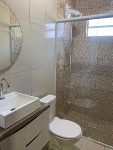 a bathroom with a shower and a toilet and a sink at CASA GAMBOA BEACH in Garopaba +21 photos