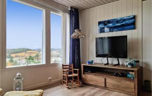 uma sala de estar com televisão e uma grande janela em 3 Bedroom Nice Home In Spangereid em Spangereid